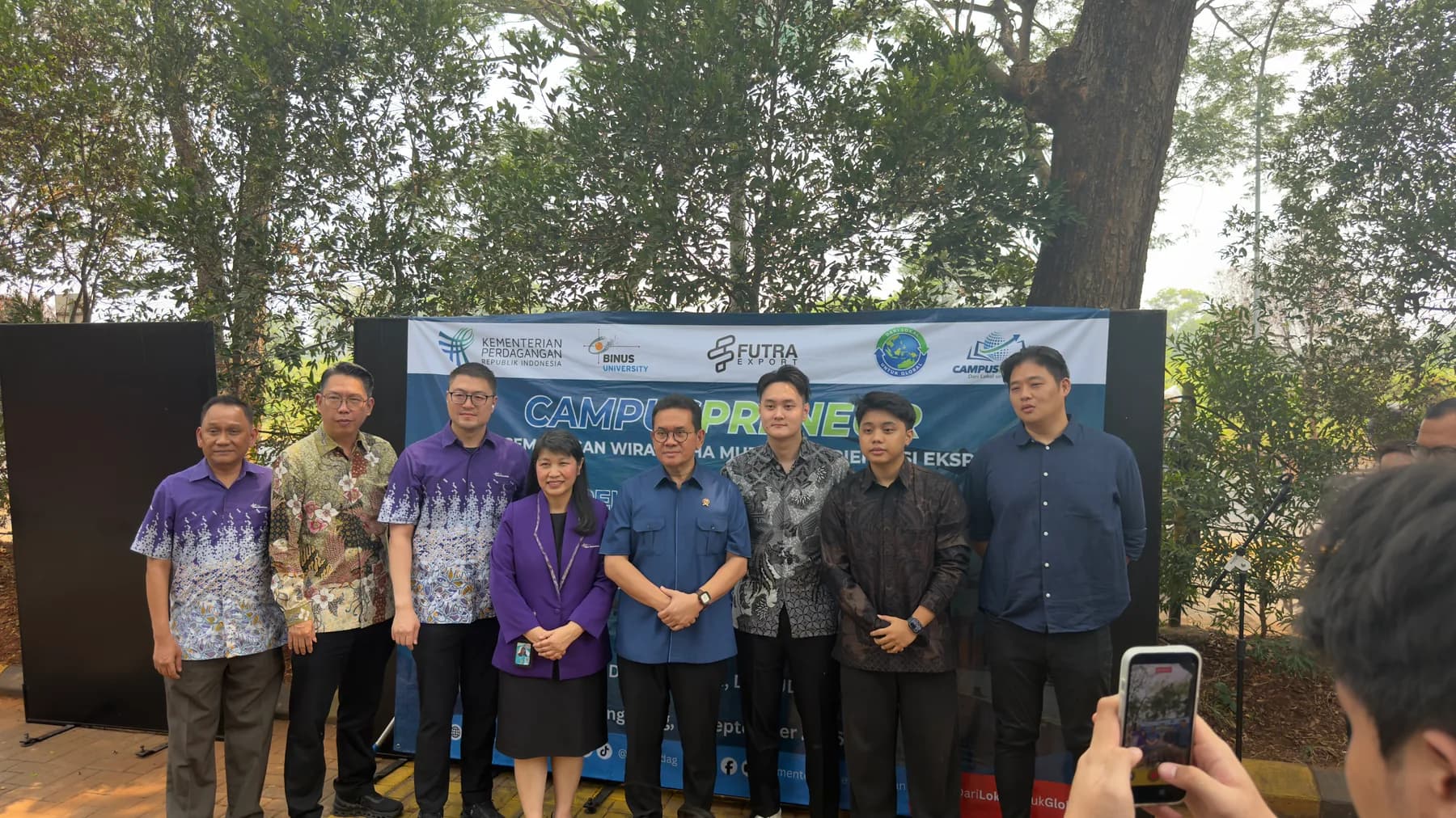 Foto bersama peserta di depan latar acara Campuspreneur